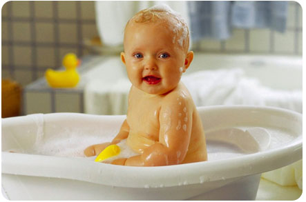 Ребенок купается в пластиковой ванночке