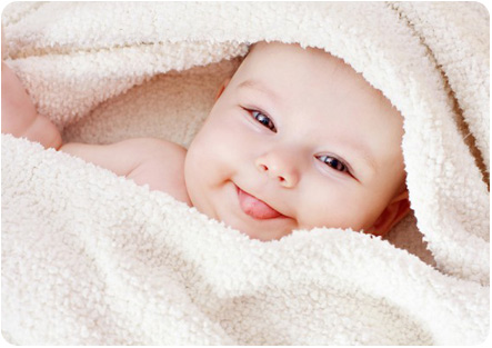 Ребенок под одеялом показывает язычок