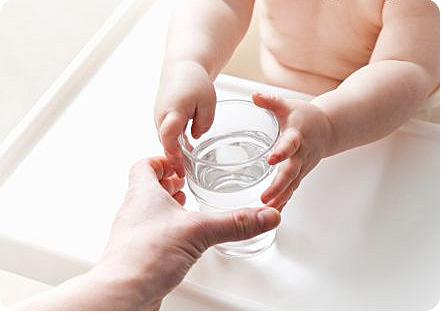 Вода в стакане для маленького ребенка