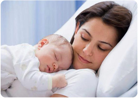 Новорожденный малыш спит на руках у мамы